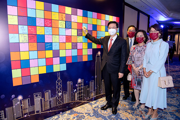 Chief Executive John Lee signs the Wishing Wall at the Chamber’s 160+1 anniversary dinner with Right-to-Left)  HKGCC Chairman Betty Yuen, Deputy Chairman Agnes Chan, and Legco Rep Jeffrey Lam. 